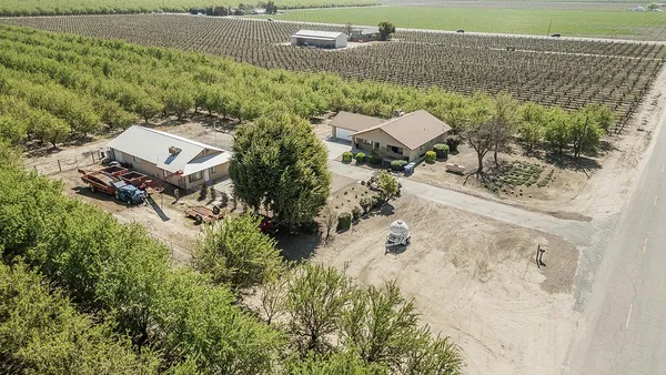 a front view of a house with a yard and potted plants