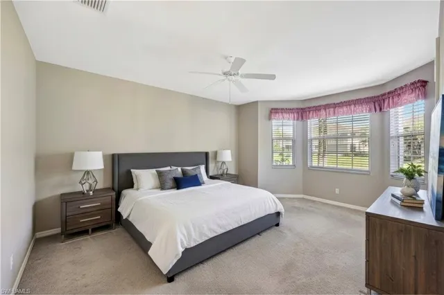 a bedroom with a large bed and wooden floor
