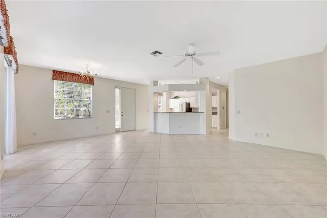 an empty room with a kitchen and a window