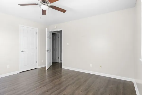 an empty room with a window and a ceiling fan