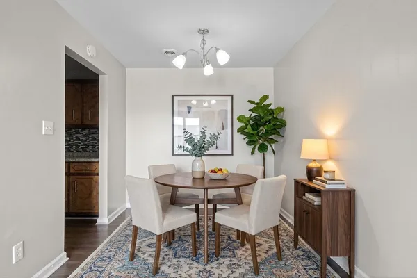 a dining room with furniture and potted plants