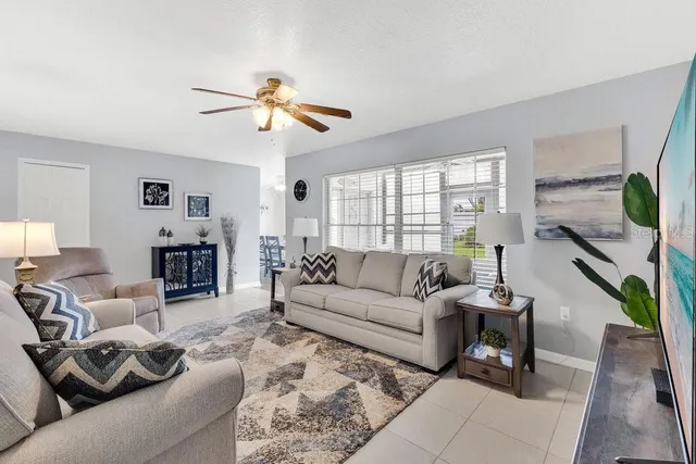 a living room with furniture ceiling fan and a window