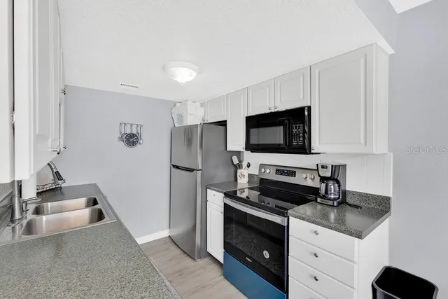 a kitchen with appliances a sink and cabinets