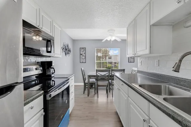 a kitchen with stainless steel appliances granite countertop a sink stove and microwave