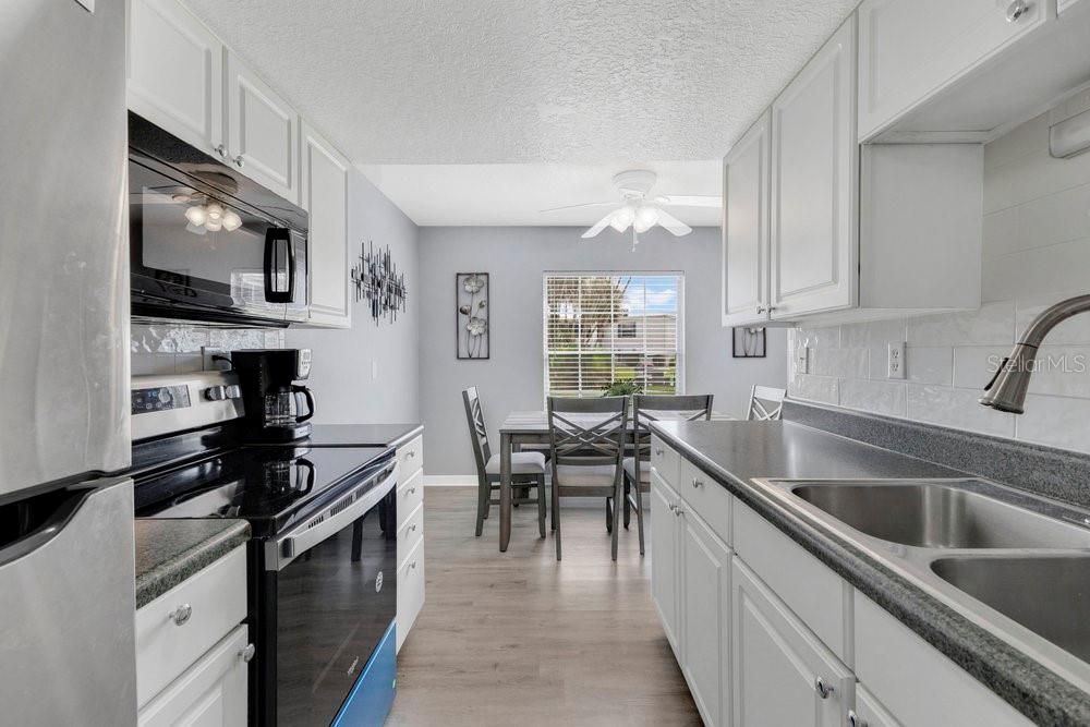 1024 North Plantation Drive, Unit B9 Kissimmee, FL 34741 - Photo 9 of 28 a kitchen with stainless steel appliances granite countertop a sink stove and microwave