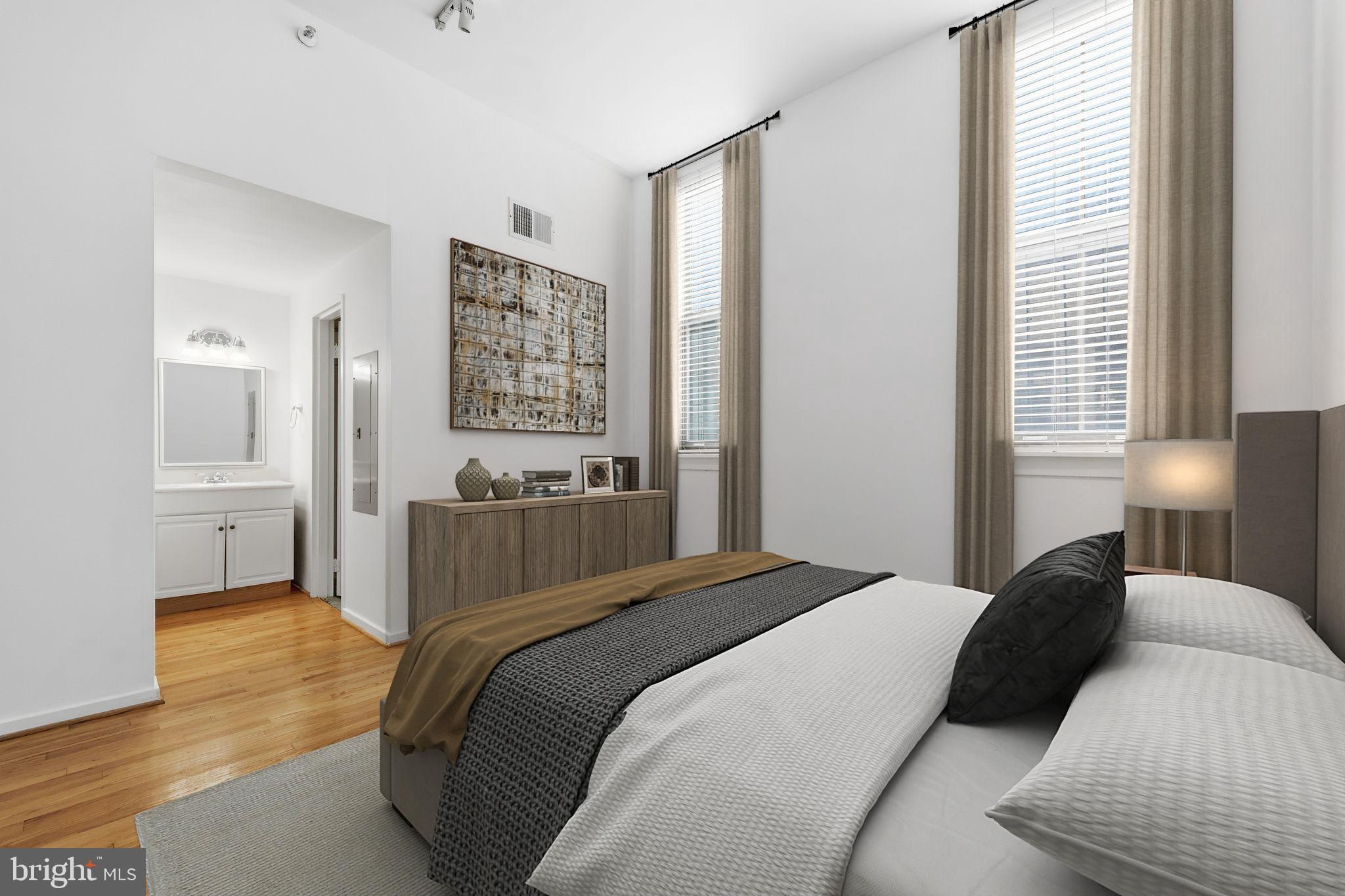 301 Race Street, Unit C010 Philadelphia, PA 19106 - Photo 17 of 32 a bedroom with a bed and a lamp with wooden floor