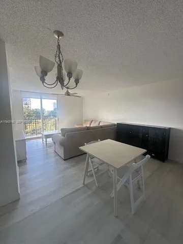 a living room with furniture a window and chandelier