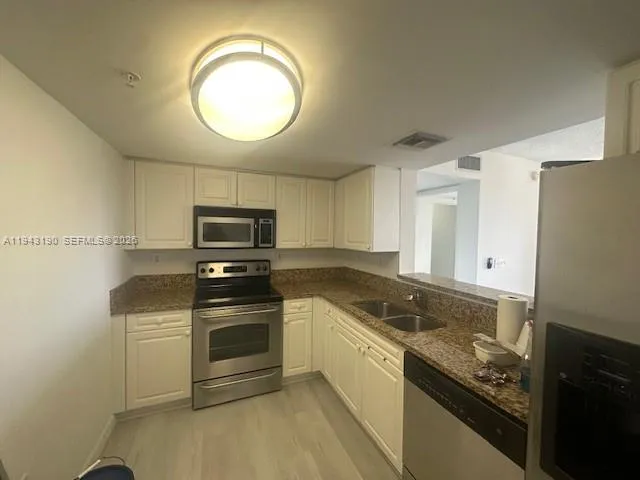 a kitchen with granite countertop a stove and a sink