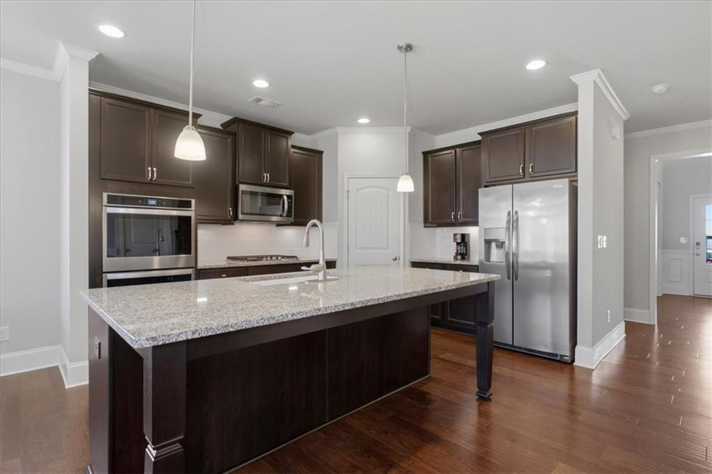 621 Little Bear Loop Canton, GA 30114 - Photo 11 of 45 a kitchen with stainless steel appliances granite countertop a refrigerator a sink a stove a microwave and wooden floor