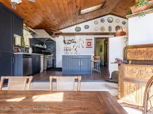 a view of a kitchen with stainless steel appliances wooden floor and chandelier