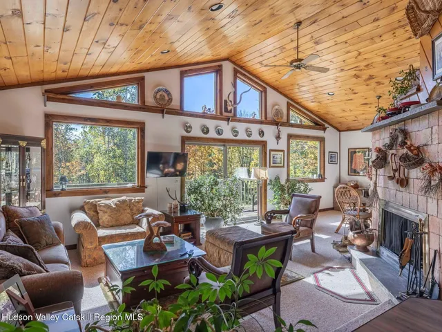 a living room with fireplace furniture and a large window
