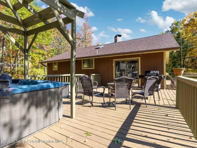 a view of a patio with table and chairs with wooden floor and fence