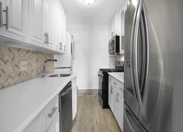 141-25 78th Avenue, Unit 3B Queens, NY 11367 - Photo 2 of 7 a kitchen with stainless steel appliances granite countertop a refrigerator and a sink