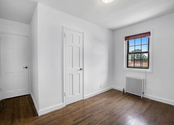 141-25 78th Avenue, Unit 3B Queens, NY 11367 - Photo 5 of 7 an empty room with wooden floor and windows