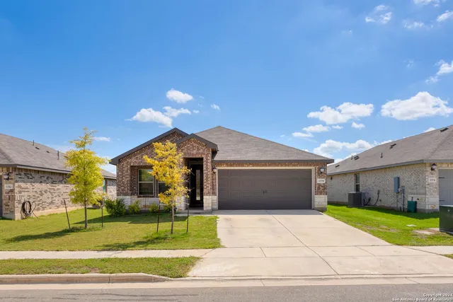 a view of a big house with a yard and garage