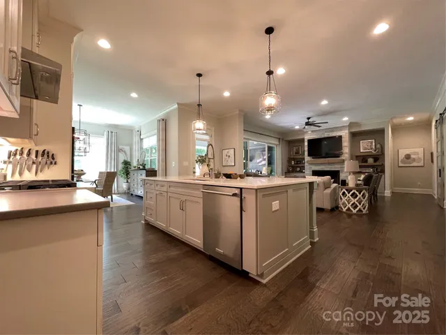 a kitchen with stainless steel appliances kitchen island granite countertop a stove top oven a sink with a dining table and chairs