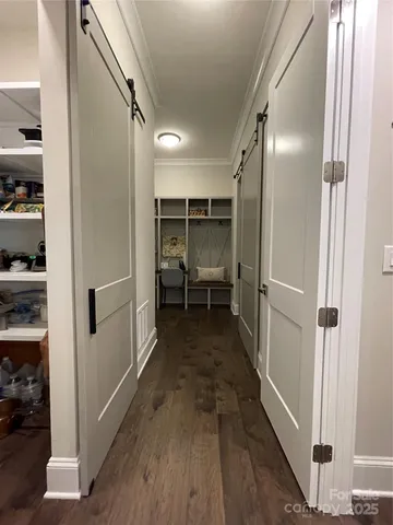a view of a hallway with wooden floor and closet
