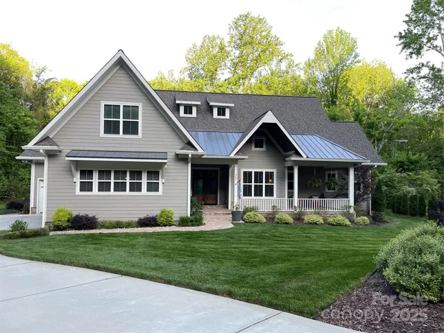 a front view of a house with a garden and trees