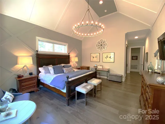 a bed room with a bed mirror and a chandelier