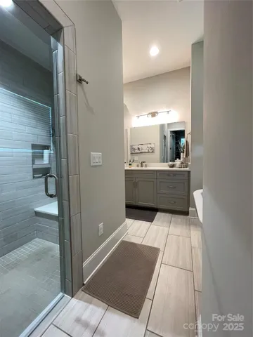 a bathroom with a tub shower a sink and a mirror