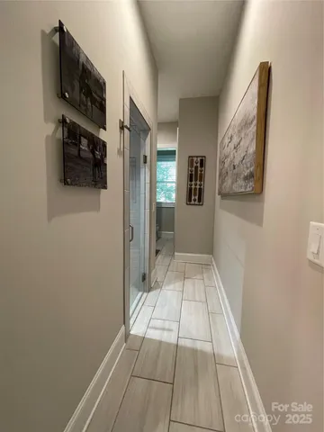 a view of a hallway with wooden floor and living room