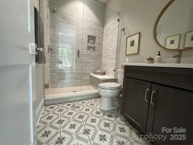 a bathroom with a sink toilet a mirror and shower