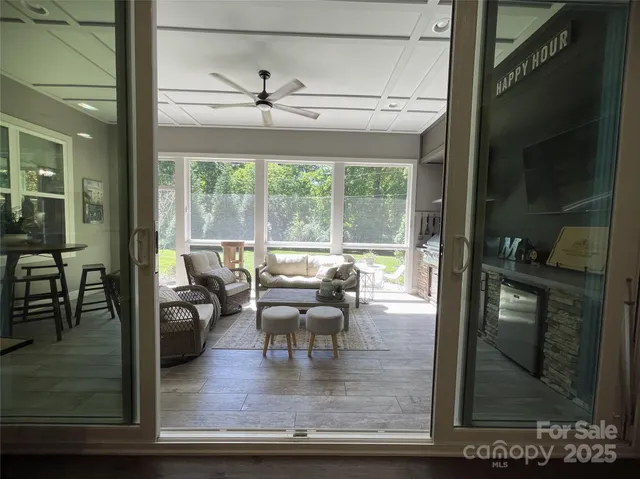 a dining room with wooden floor and a floor to ceiling window