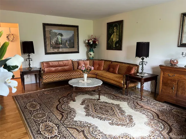 a living room with furniture a flat screen tv and a table