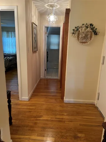a view of a hallway to a room with wooden floor