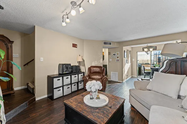 a living room with furniture and a wooden floor