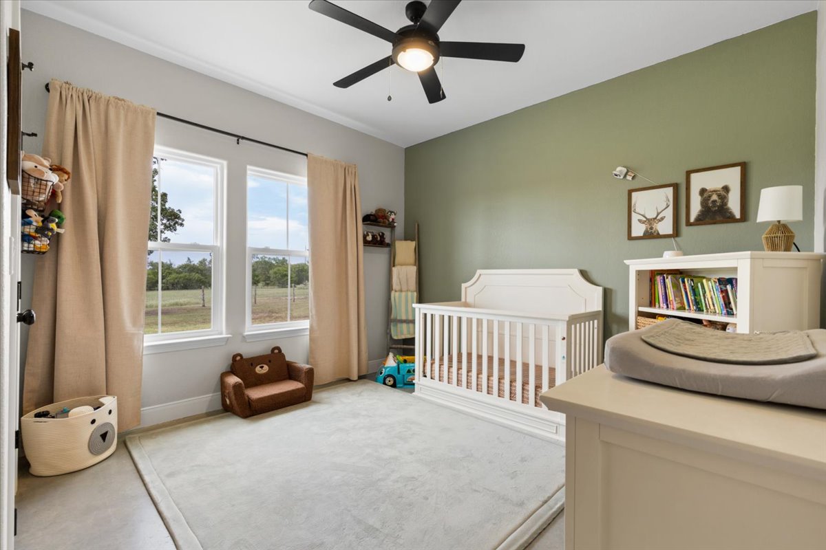 3389 Sparta Field Road Waelder, TX 78959 - Photo 18 of 40 Bedroom with a ceiling fan and concrete flooring