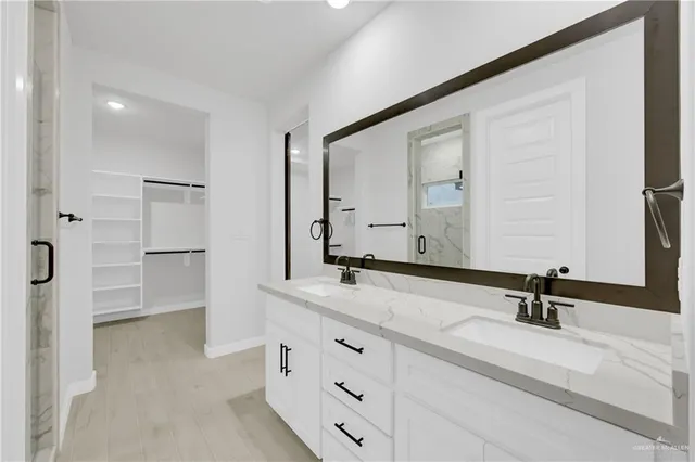 a bathroom with a shower sink and mirror