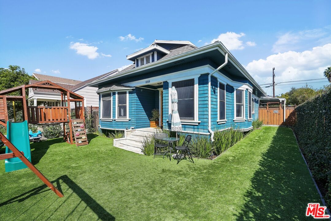 a front view of a house with a yard table and chairs