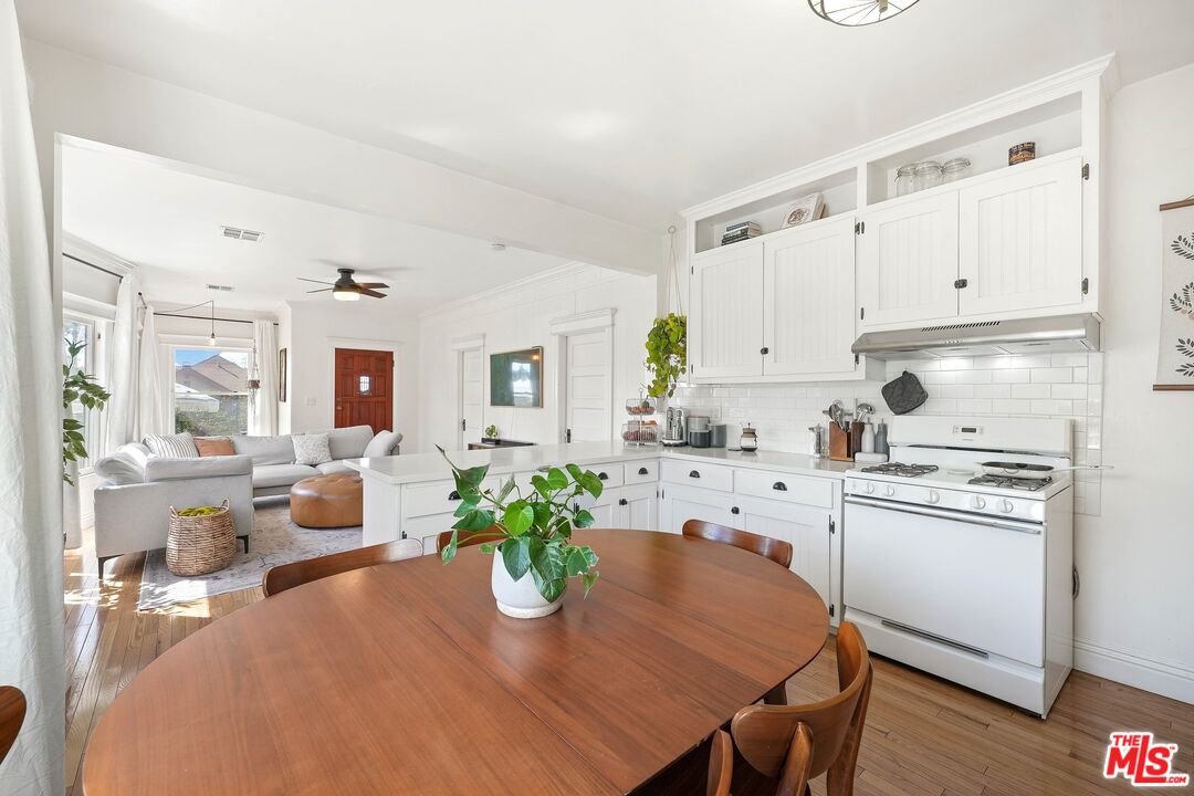 5159 Meridian Street Los Angeles, CA 90042 - Photo 11 of 41 a kitchen with white cabinets and wooden floor