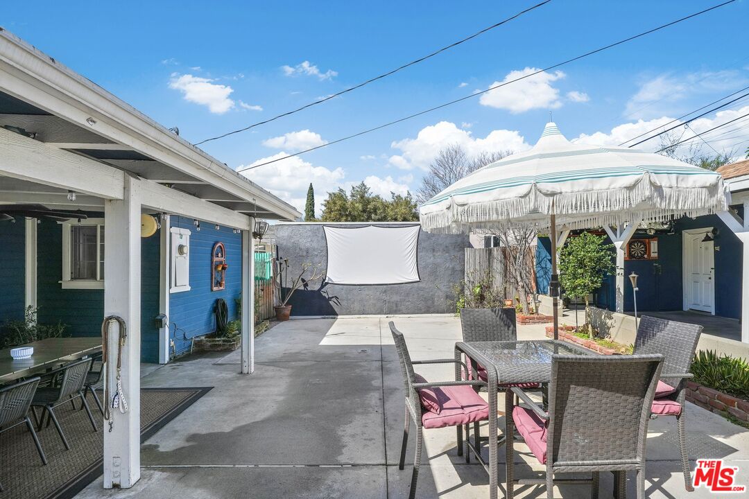 5159 Meridian Street Los Angeles, CA 90042 - Photo 29 of 41 a view of a patio with a table and chairs under an umbrella with a barbeque