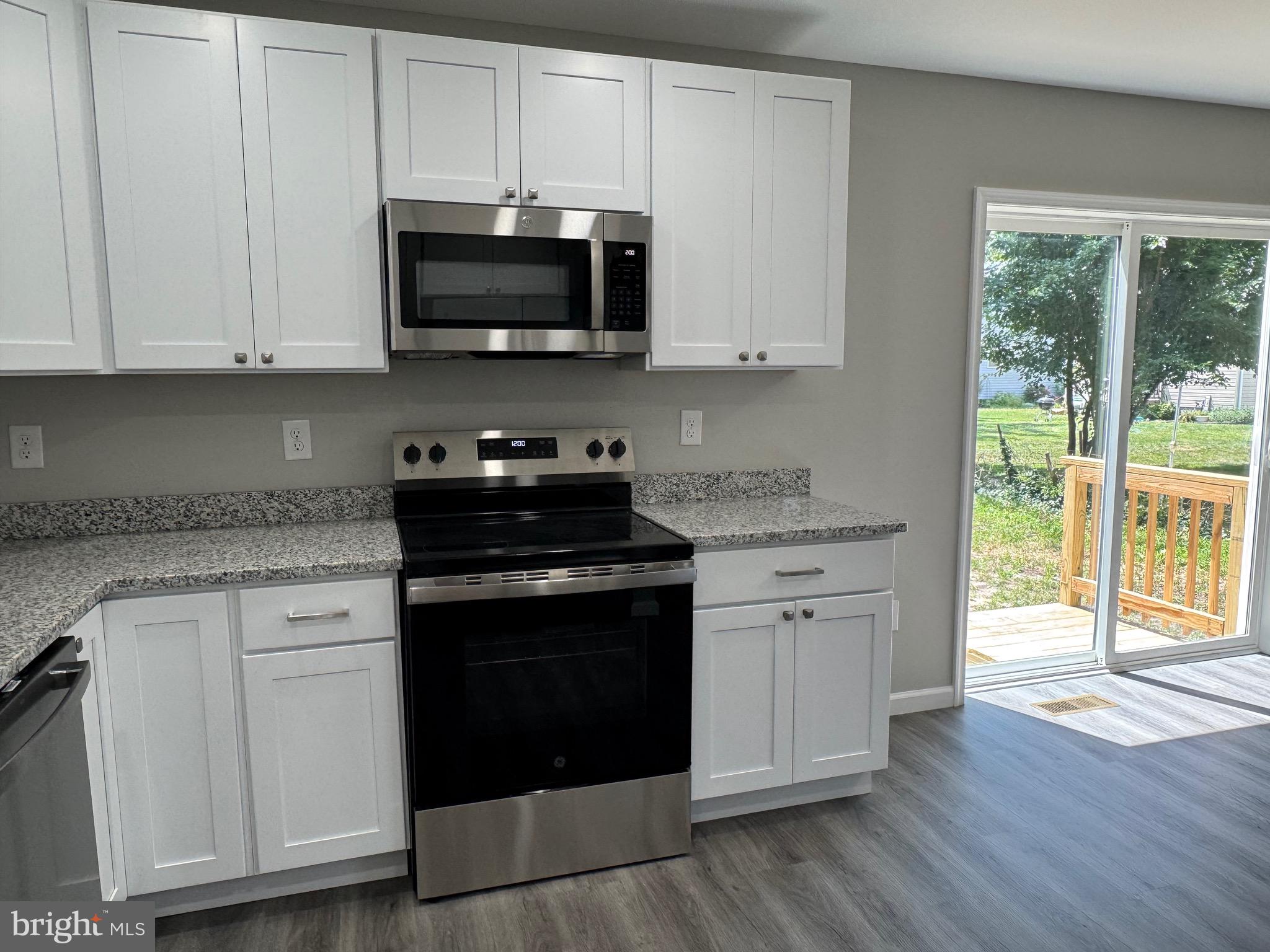 210 West 2nd Street Ridgely, MD 21660 - Photo 13 of 36 a kitchen with stainless steel appliances granite countertop a stove a sink and white cabinets