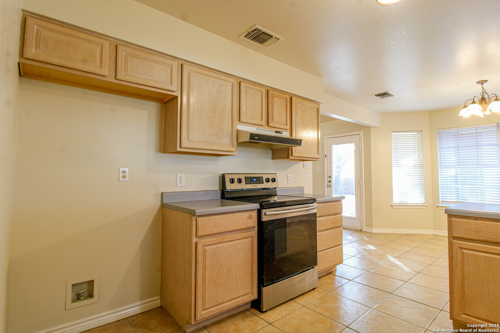 6703 Ridge Pl Street San Antonio, TX 78250 - Photo 16 of 44 a kitchen with stainless steel appliances granite countertop a stove a sink and white cabinets