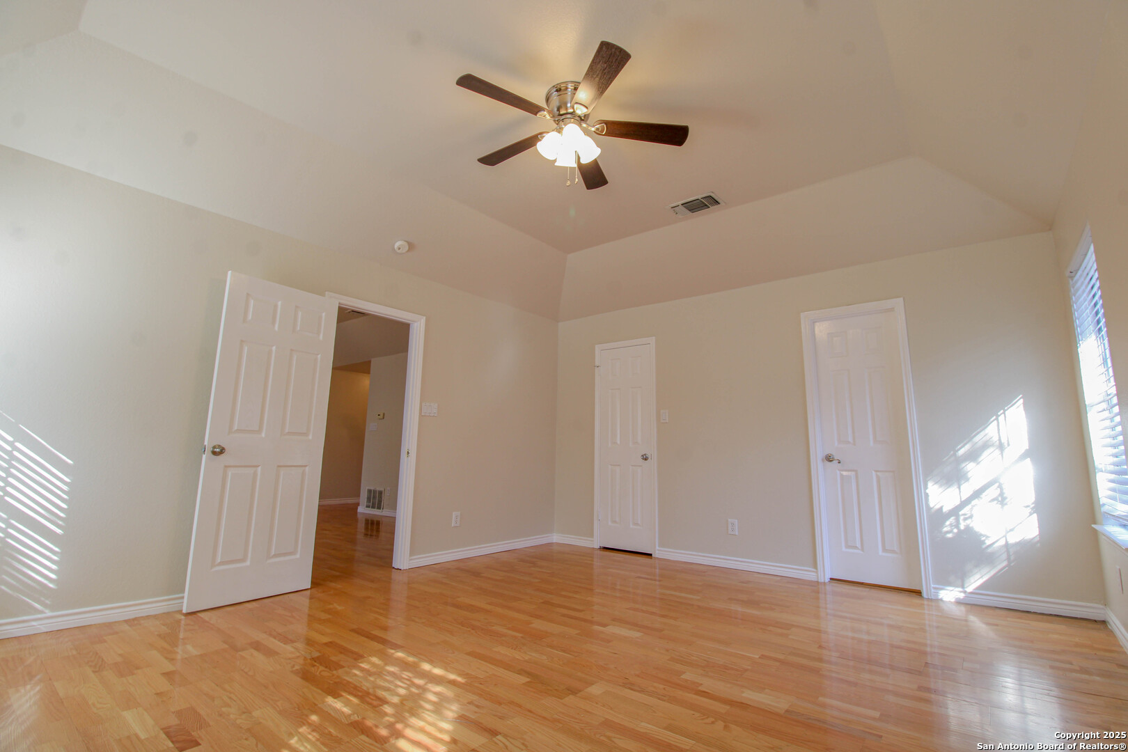 6703 Ridge Pl Street San Antonio, TX 78250 - Photo 23 of 44 a view of an empty room with wooden floor and a ceiling fan