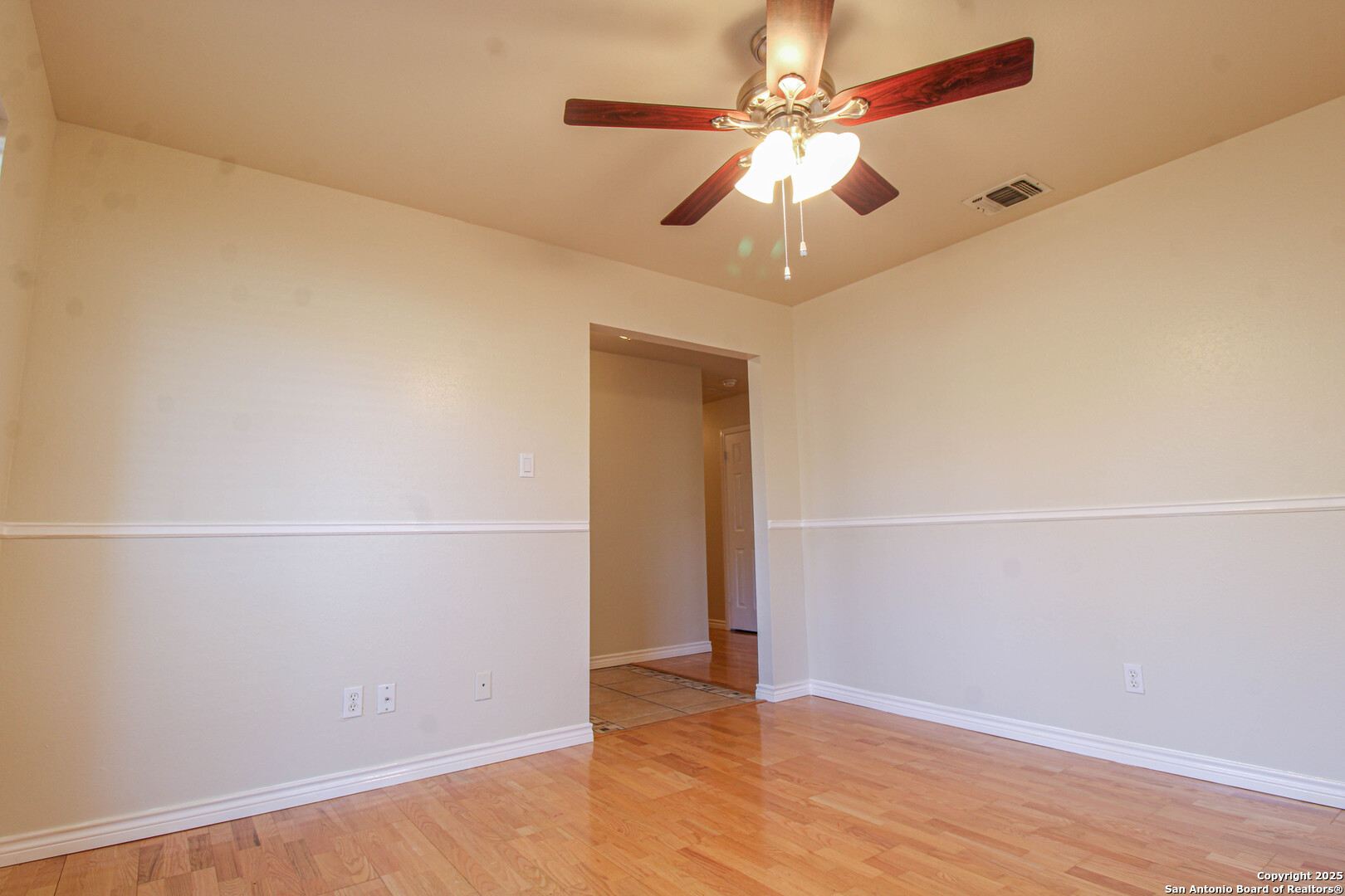 6703 Ridge Pl Street San Antonio, TX 78250 - Photo 7 of 44 an empty room with wooden floor and fan