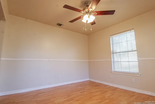 an empty room with a window and a fan