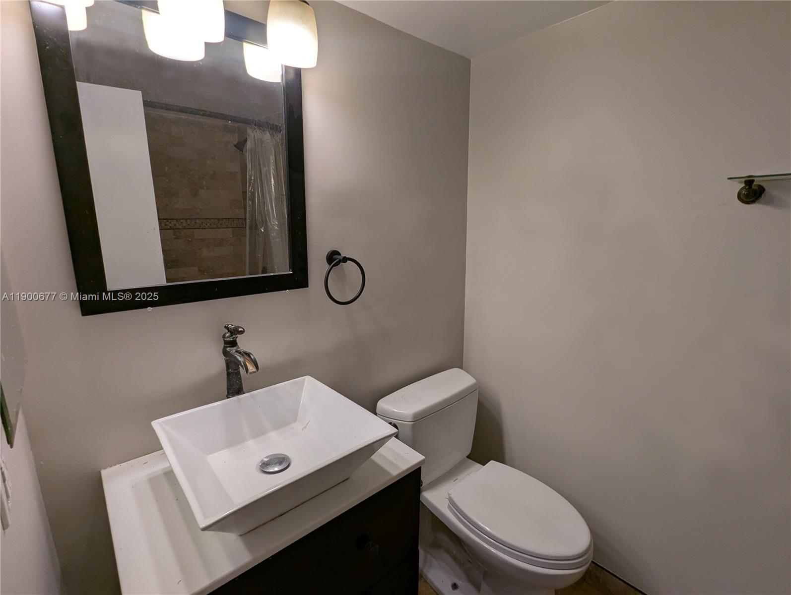 3400 Foxcroft Road, Unit 115 Miramar, FL 33025 - Photo 14 of 16 a bathroom with a toilet a sink and mirror