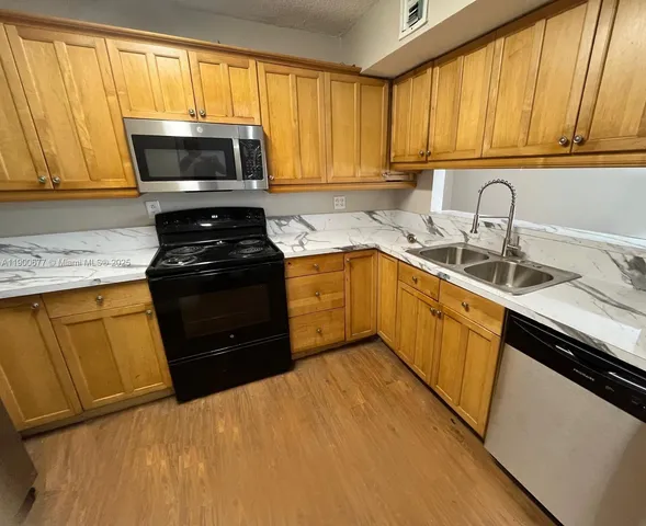 a kitchen with a sink a stove and cabinets