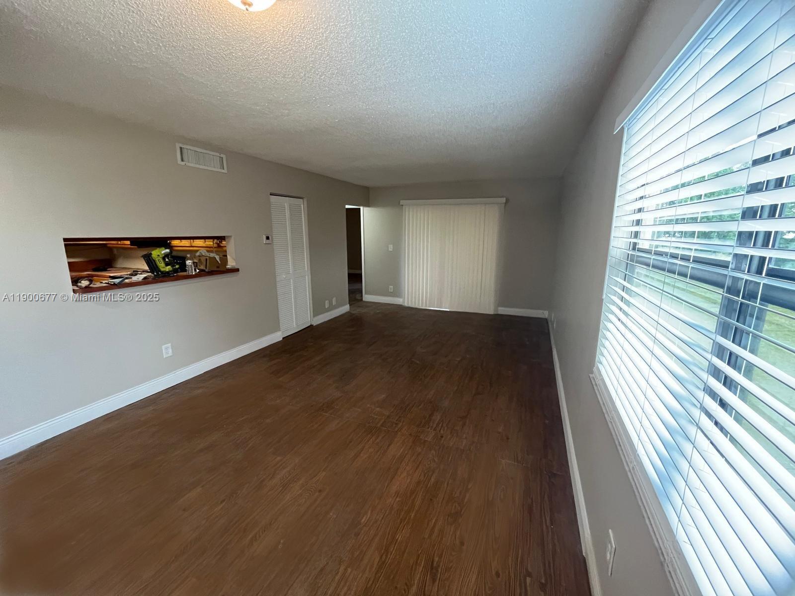 3400 Foxcroft Road, Unit 115 Miramar, FL 33025 - Photo 8 of 16 an empty room with wooden floor and windows