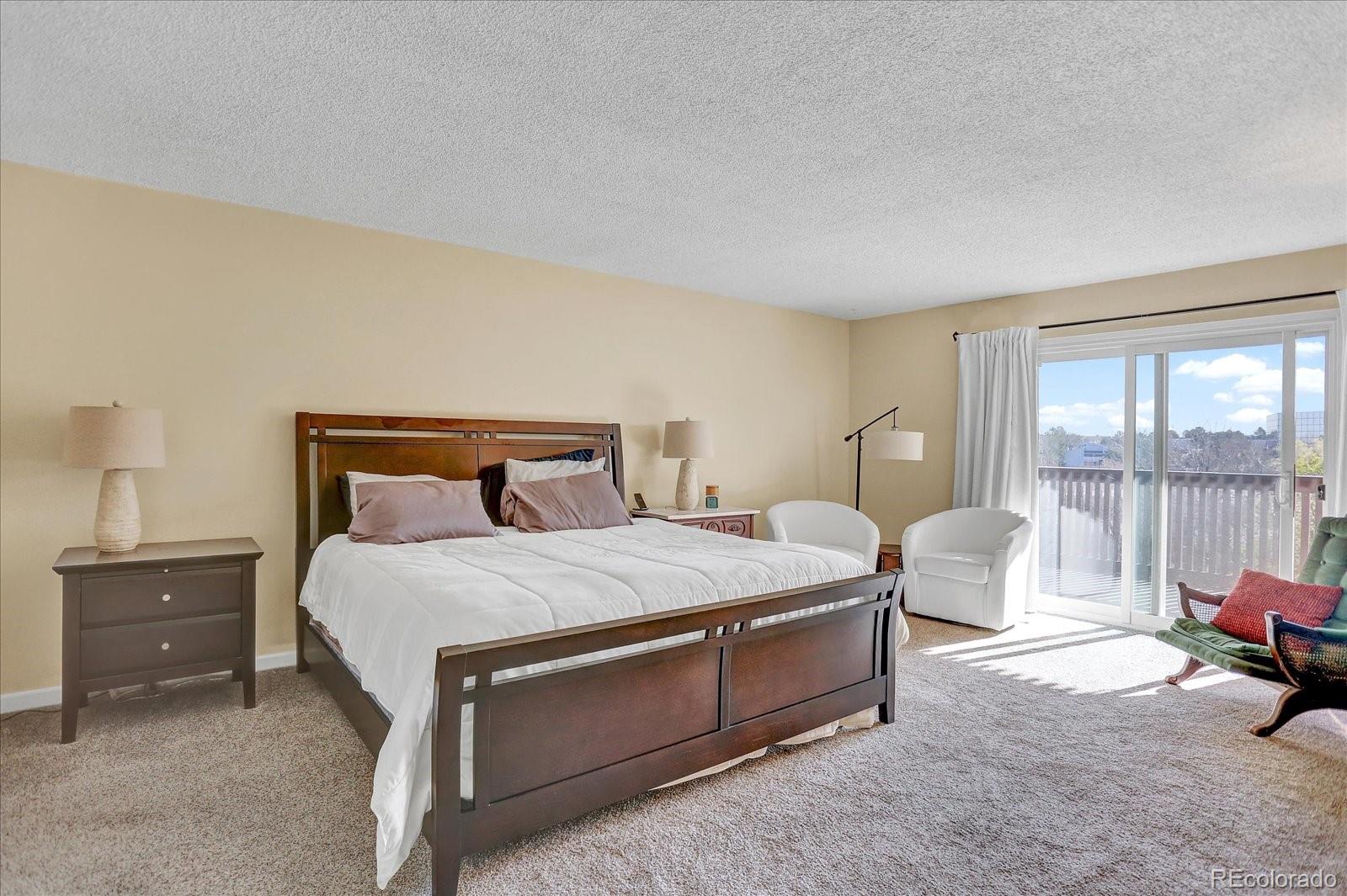 7040 East Girard Avenue, Unit E406 Denver, CO 80224 - Photo 11 of 27 a bedroom with a bed and large windows