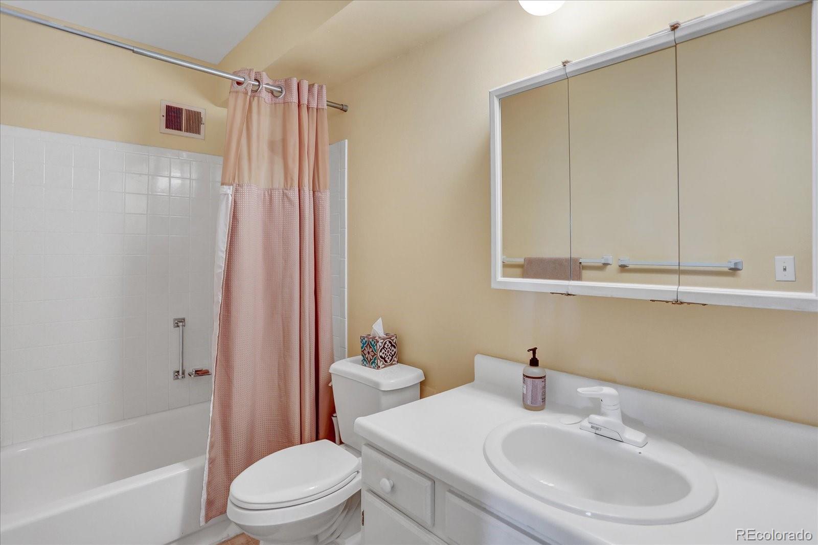 7040 East Girard Avenue, Unit E406 Denver, CO 80224 - Photo 17 of 27 a bathroom with a sink toilet and shower