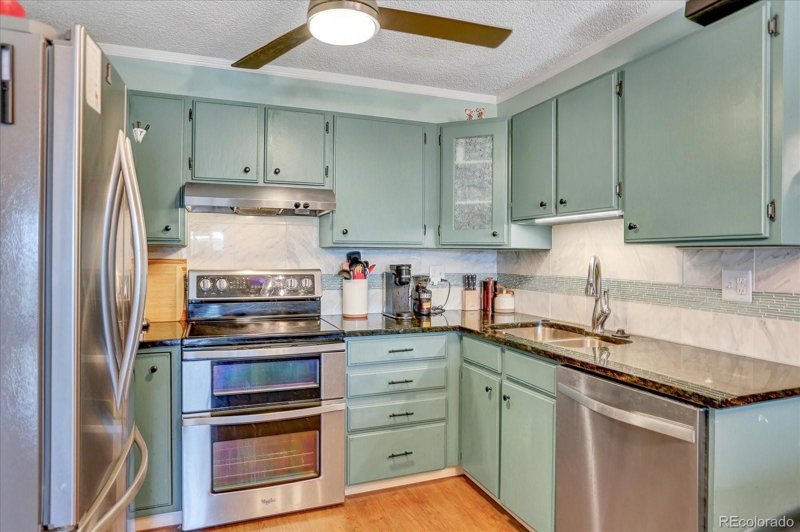 7040 East Girard Avenue, Unit E406 Denver, CO 80224 - Photo 2 of 27 a kitchen with stainless steel appliances granite countertop a refrigerator and a stove