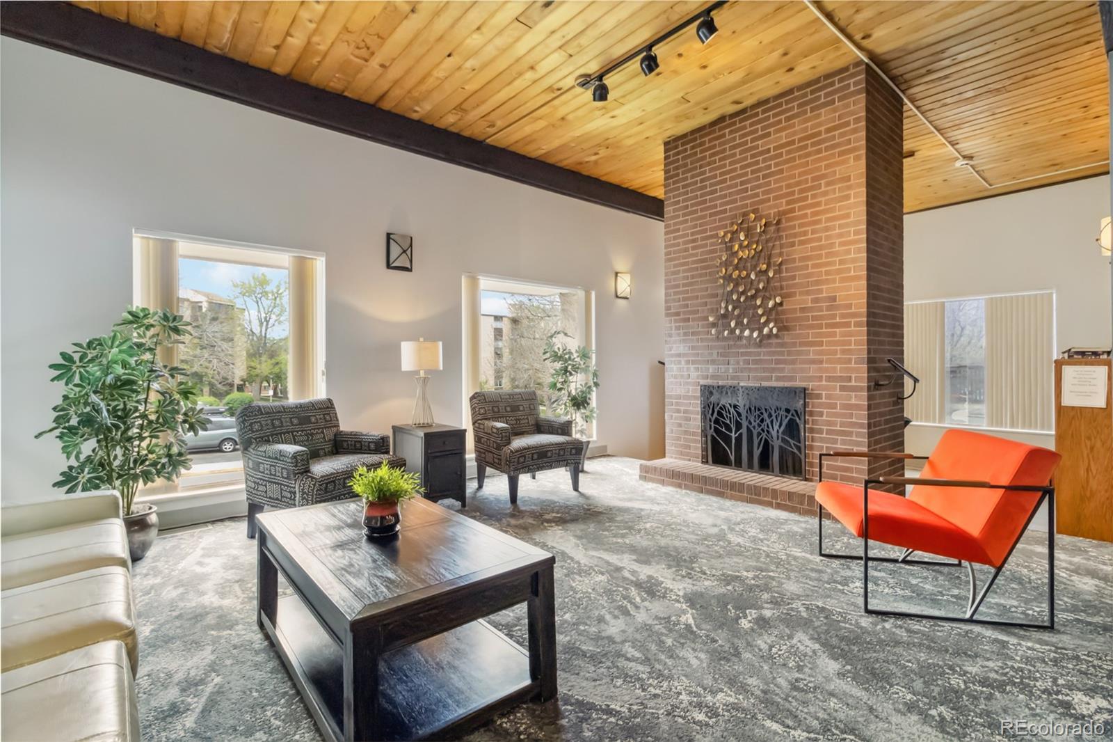 7040 East Girard Avenue, Unit E406 Denver, CO 80224 - Photo 21 of 27 a living room with patio a couch and a fireplace