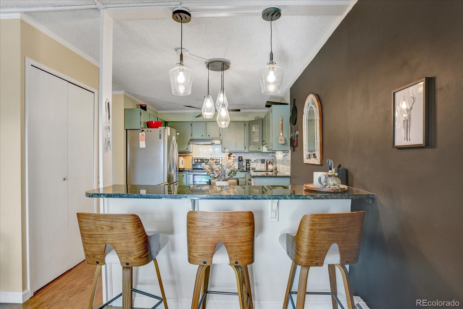 7040 East Girard Avenue, Unit E406 Denver, CO 80224 - Photo 3 of 27 a view of a dining room with furniture and chandelier