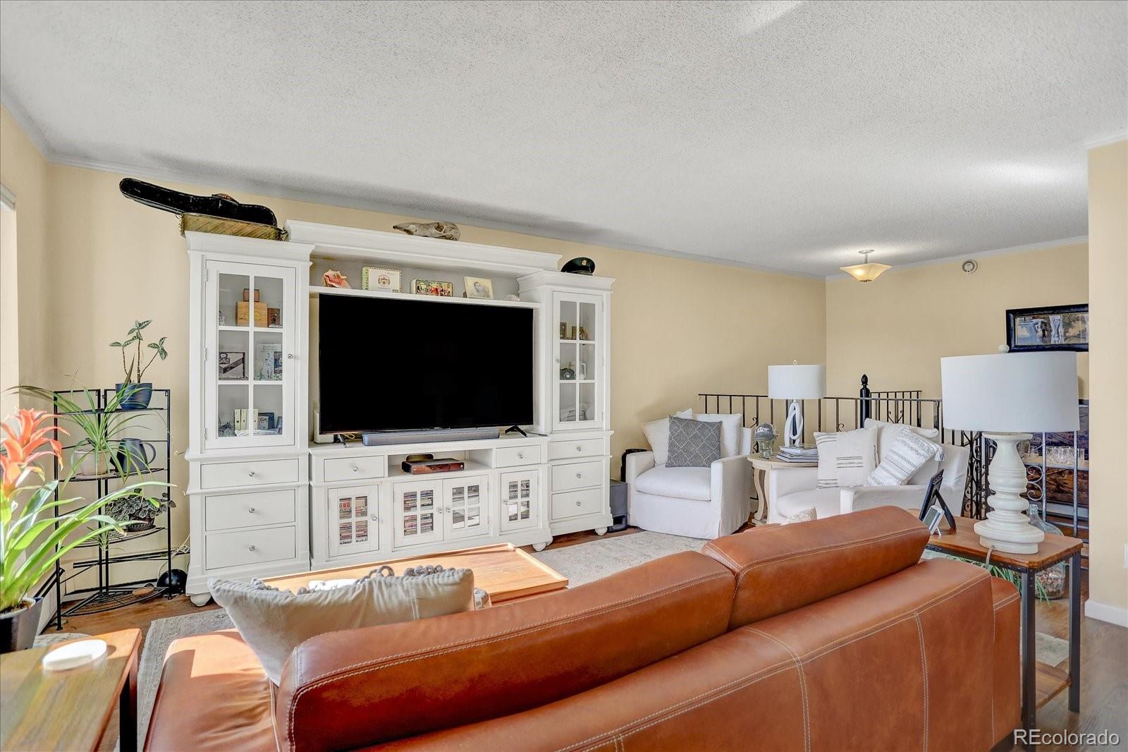7040 East Girard Avenue, Unit E406 Denver, CO 80224 - Photo 7 of 27 a living room with furniture and a flat screen tv