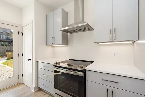 a kitchen with granite countertop white cabinets and white appliances